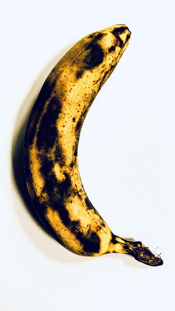 Fresh ripe banana with natural spots on textured white background vibrant yellow fruit Wallpaper