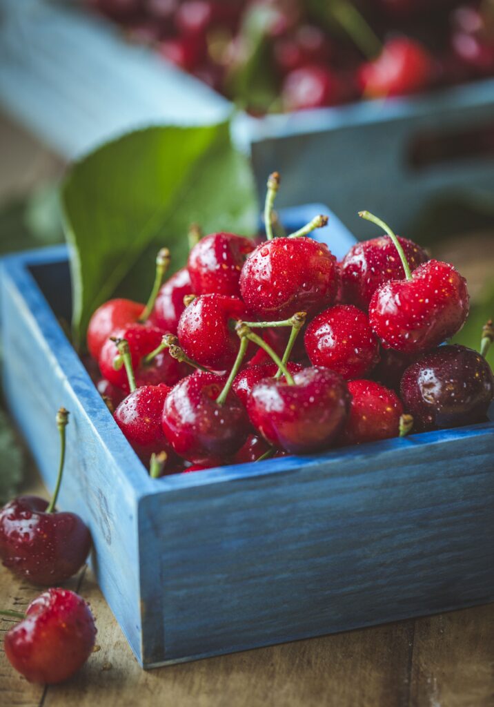Fresh Ripe Cherries with Water Drops in Blue Wooden Box Wallpaper