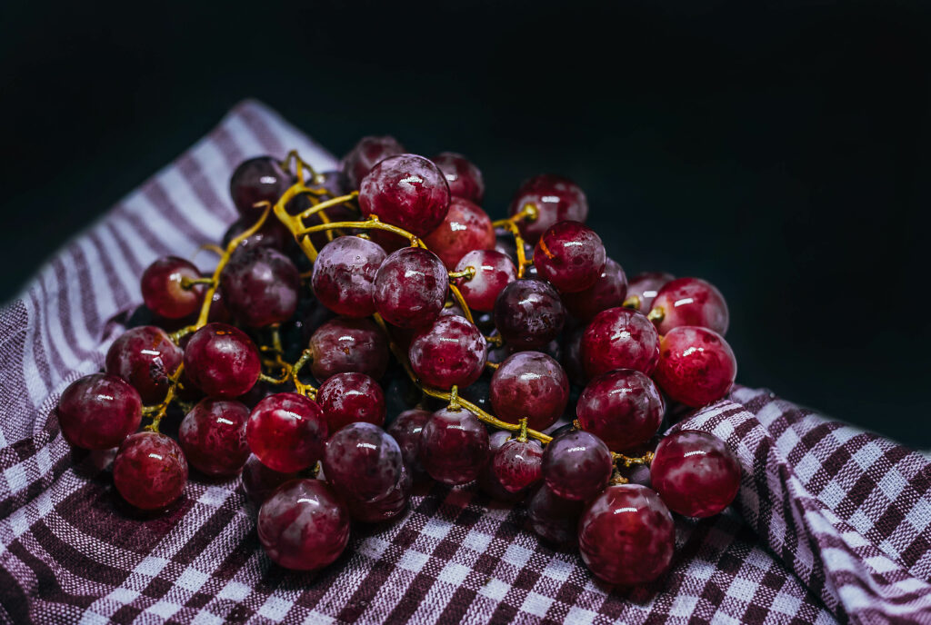 Juicy Red Grapes Wallpaper: Close-Up on Checkered Background