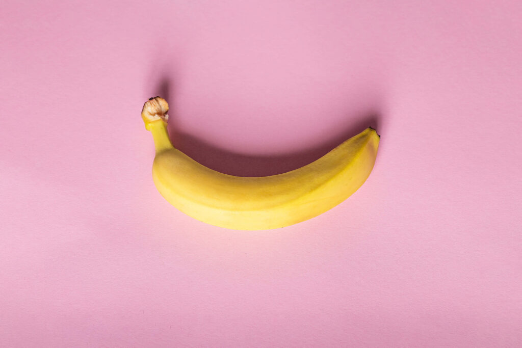 Ripe yellow banana on pastel pink background fresh fruit vibrant tropical wallpaper