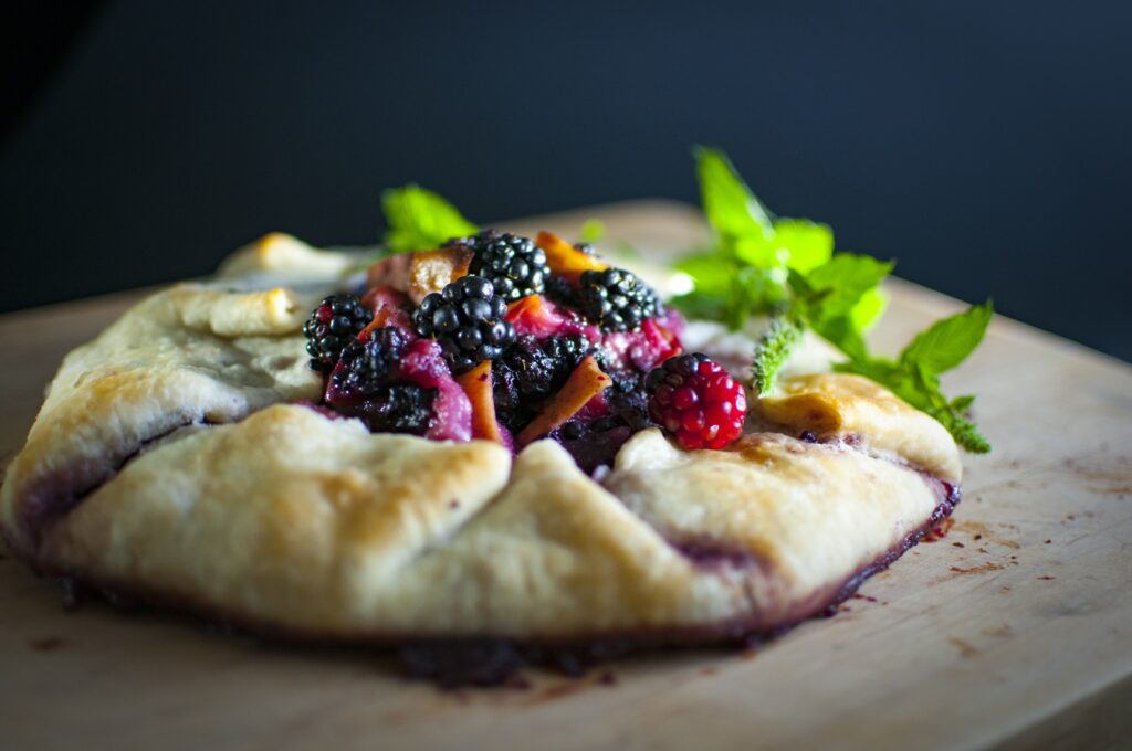 Rustic Berry Galette on Wood: A Charming Wallpaper Background