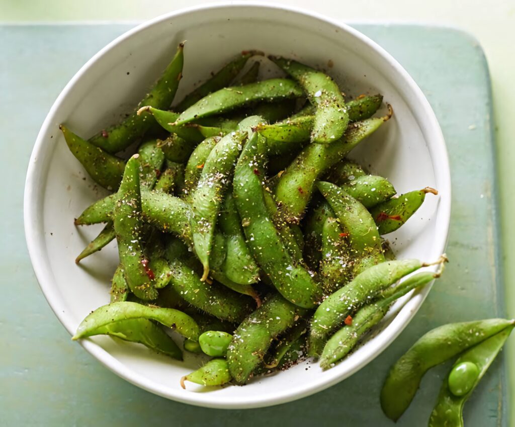 Vibrant spicy edamame beans seasoned and arranged on plate healthy snack wallpaper background