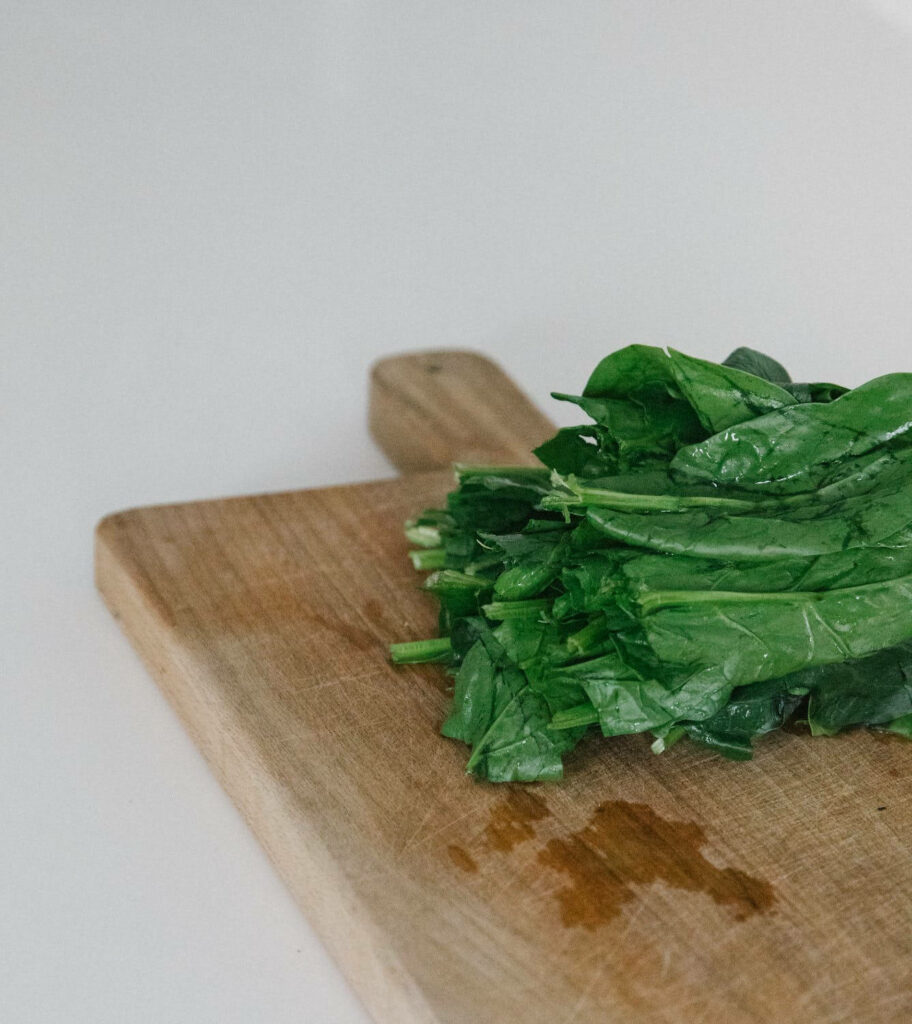 Fresh Spinach Wallpaper on Rustic Cutting Board: Natural Aesthetic