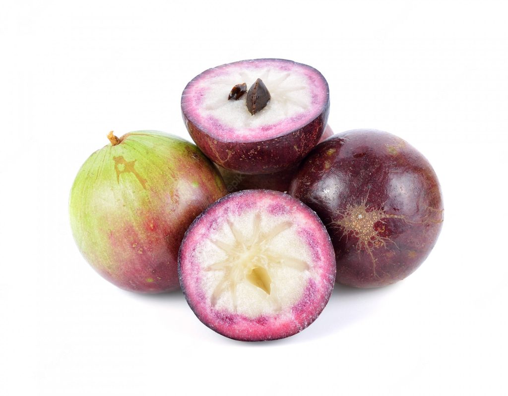 Fresh whole and halved Star Apples showing white star pulp on a clean white background studio photo Wallpaper