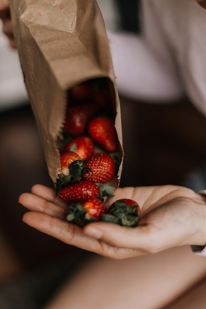 Fresh Strawberries Spilling from Paper Bag - Vibrant Wallpaper Image