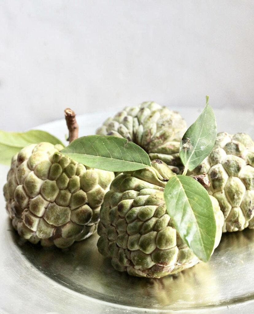 Textured Green Sugar Apples Close-Up Wallpaper on Reflective Surface