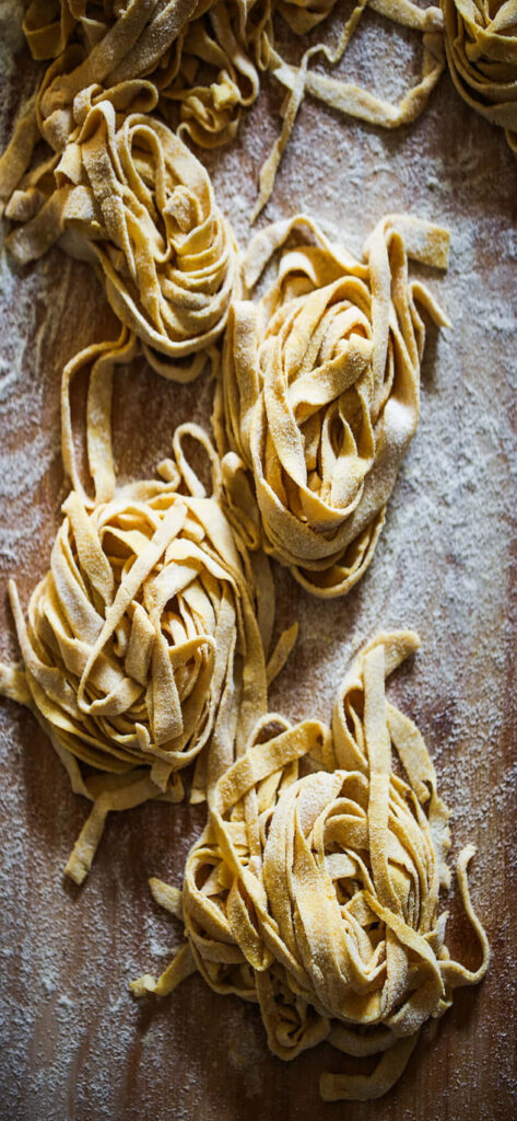 Rustic Golden Tagliatelle Pasta Nests on Floured Wood - Wallpaper