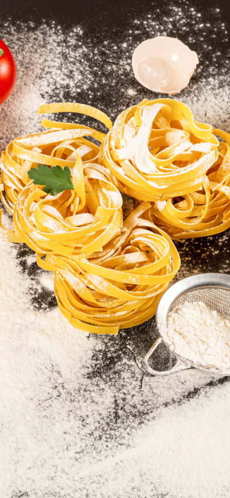 Fresh Tagliatelle Nests with Flour: Rustic Pasta Wallpaper Background