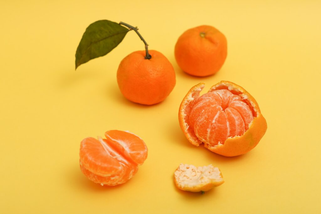 Cheerful Tangerine Wallpaper: Fresh Fruit on Bright Yellow Background