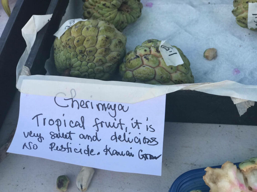 Fresh green Cherimoya fruit with handwritten note highlighting sweet pesticide-free Hawaii harvest wallpaper