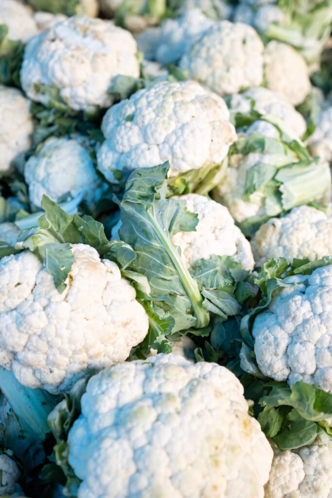 Close up white cauliflower with green leaves high resolution fresh organic vegetable wallpaper background