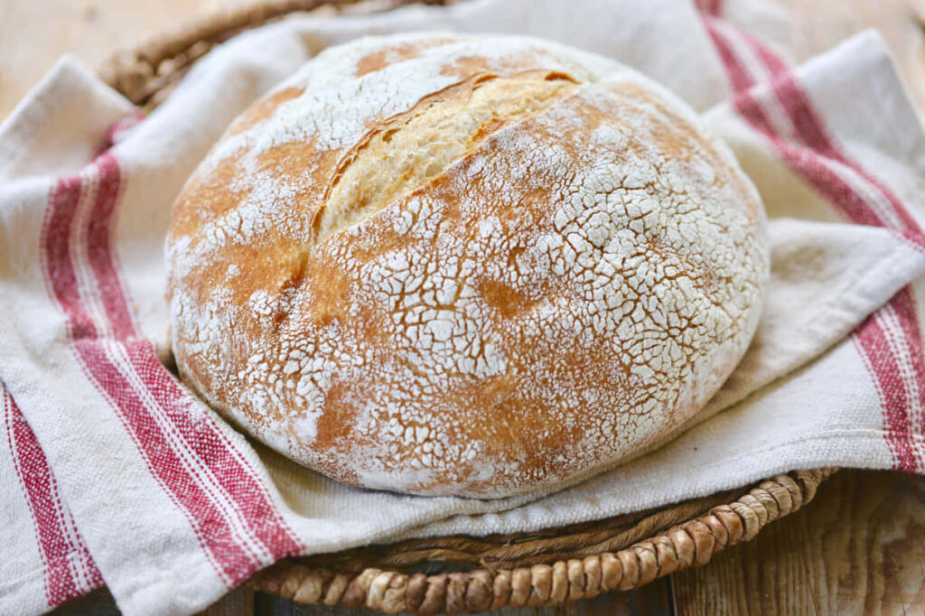 Rustic Golden-Brown Crusty Bread in Woven Basket - Wallpaper Background