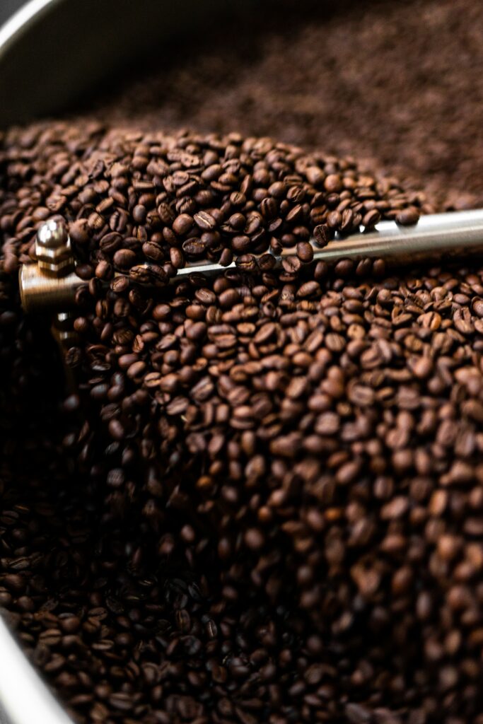 Close-Up: Freshly Roasted Coffee Beans & Metallic Grinder Wallpaper