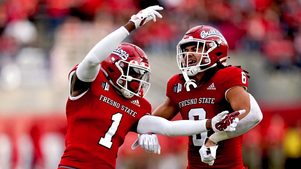 Fresno State Bulldogs defensive back and linebacker celebrate interception vs Nevada Wolf Pack in red uniforms Wallpaper