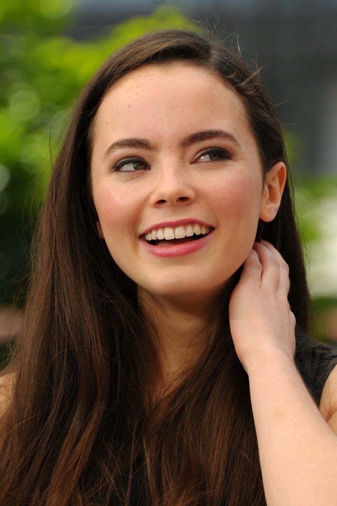 Freya Tingley natural smile portrait bright light dark hair blurred green garden background Wallpaper