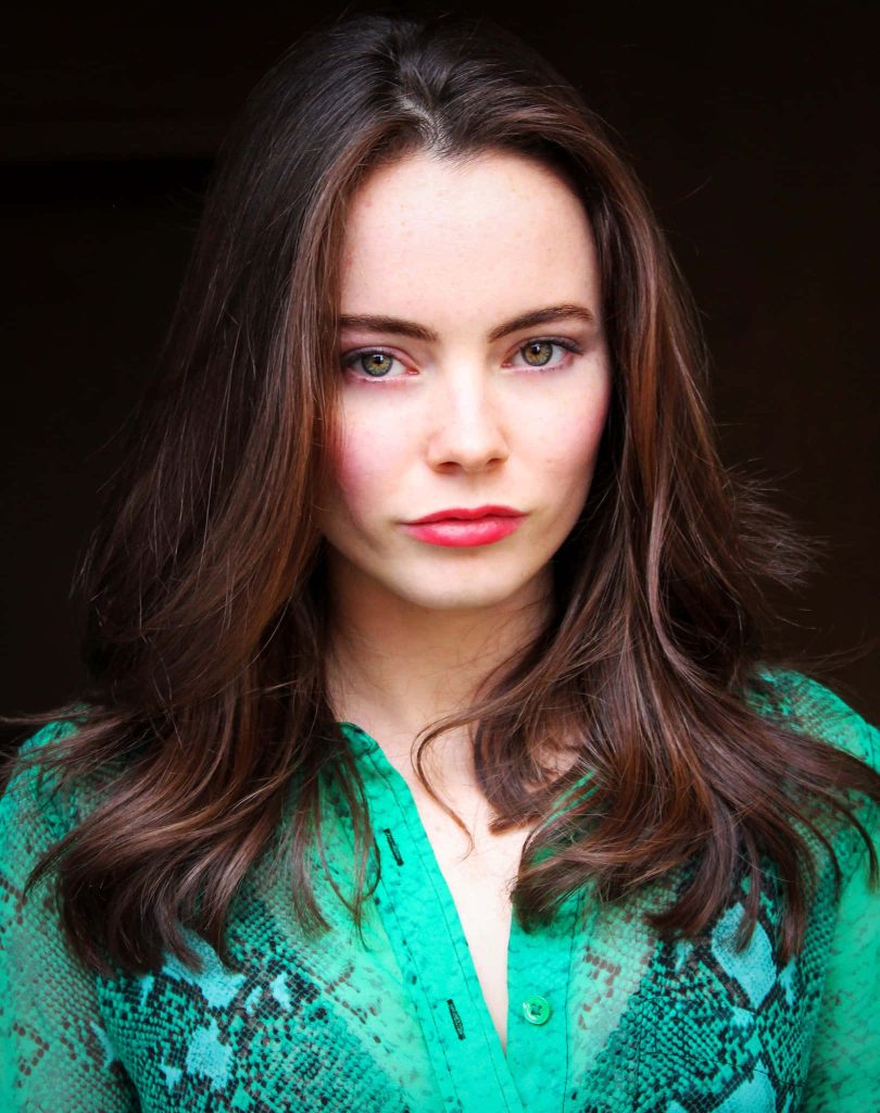 Studio portrait of actress Freya Tingley in green snakeskin top with intense gaze dark background Wallpaper