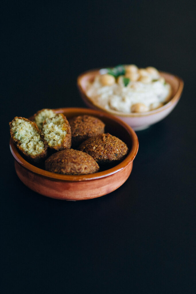 Delicious Fried Falafels with Hummus Dip on Dark Wallpaper Background