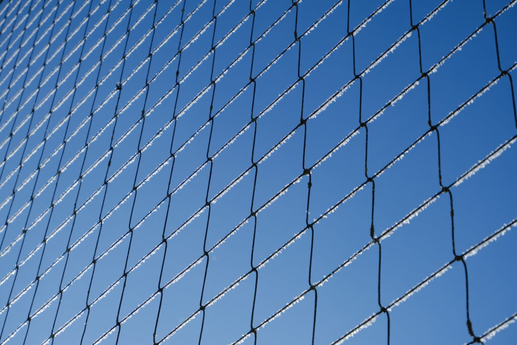 Frosted Mesh Close-Up Against Blue Sky: Intricate Macro Wallpaper