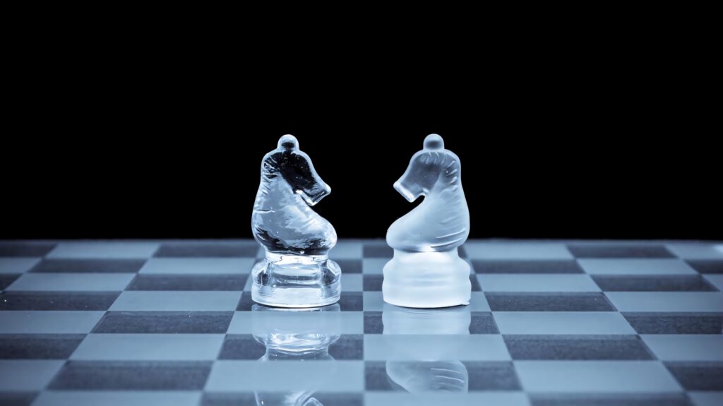 Frosted glass chess knights facing on reflective board with textured matte clear contrast background Wallpaper