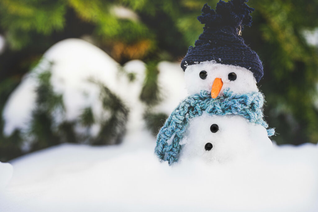 Winter's Charming Guardian: A Delightful Snowman Adorned in a Cozy Bonnet and Scarf, Embracing the Serenity of a Cool Winter Wallpaper