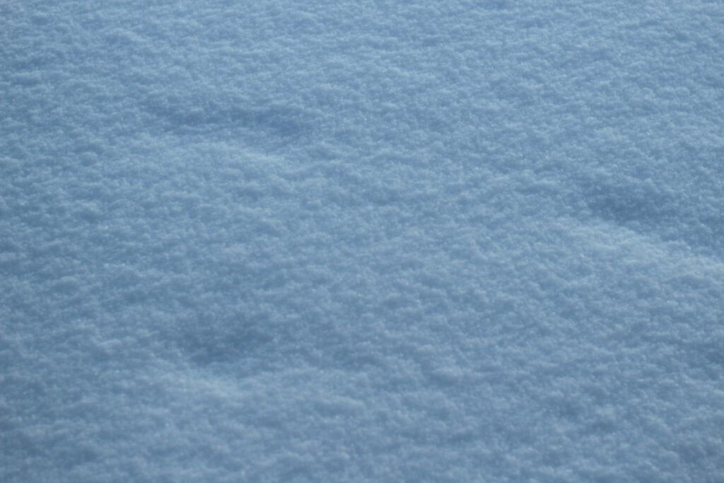 Blue-tinted fresh snow texture on a tranquil winter day Wallpaper