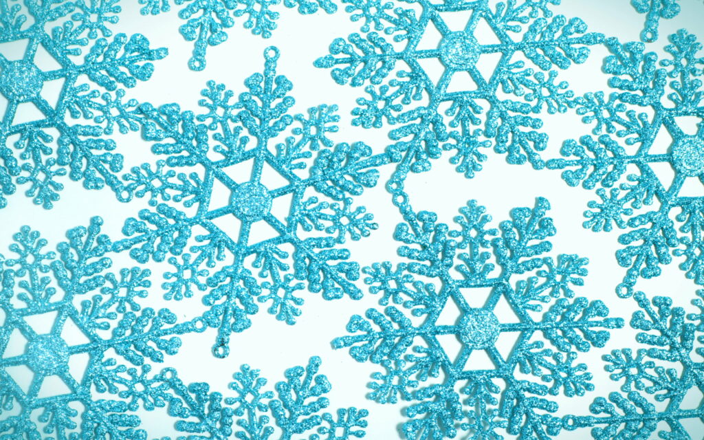Frozen Symphony: Captivating Blue Snowflake Patterns in a Macro Winter Wonderland Wallpaper