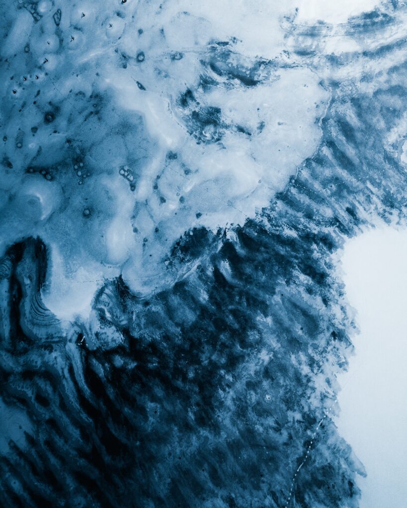 Close-up of glacier ice textures with abstract blue patterns showcasing icy landscape beauty Wallpaper