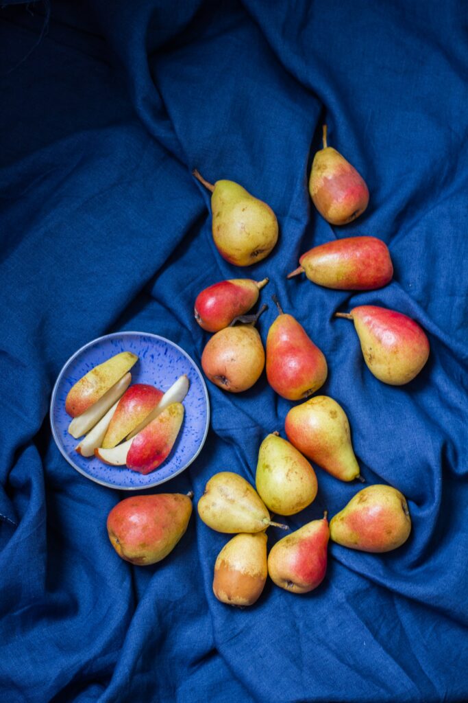 Vibrant Pears Wallpaper: Ripe Fruits on Blue Cloth & Plate