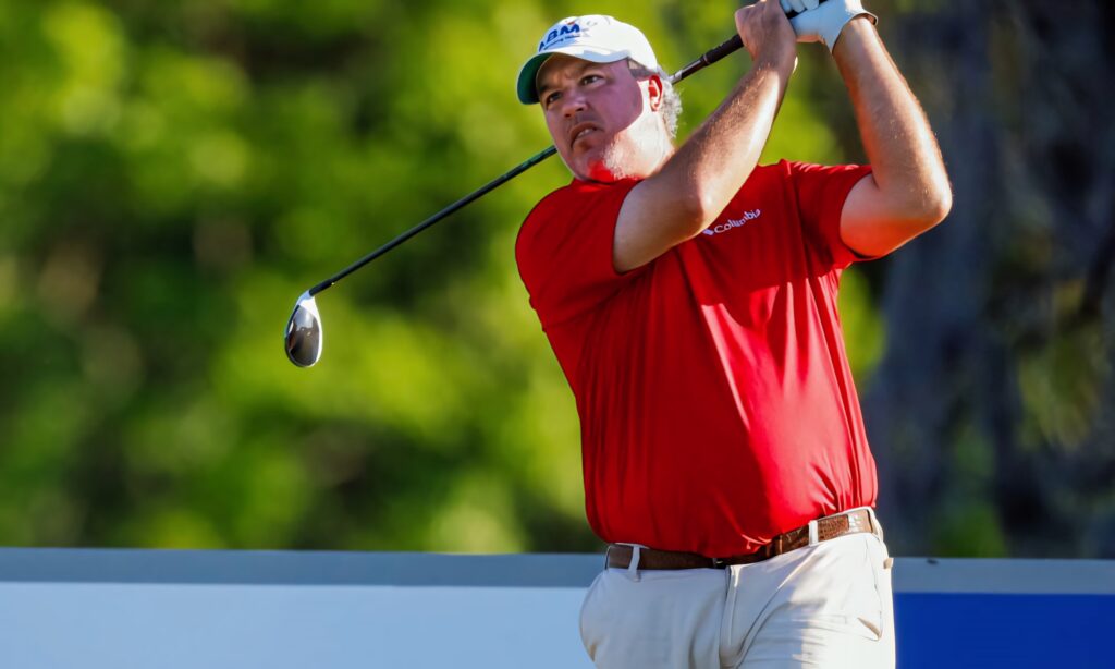 Frustrated Boo Weekley golf wallpaper showing intense emotion on green course in red shirt