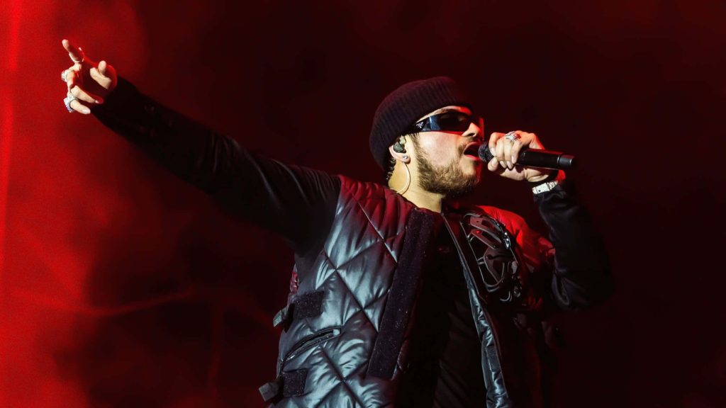 Jesús Ortiz Paz live concert wallpaper Fuerza Regida red stage lights black beanie vest