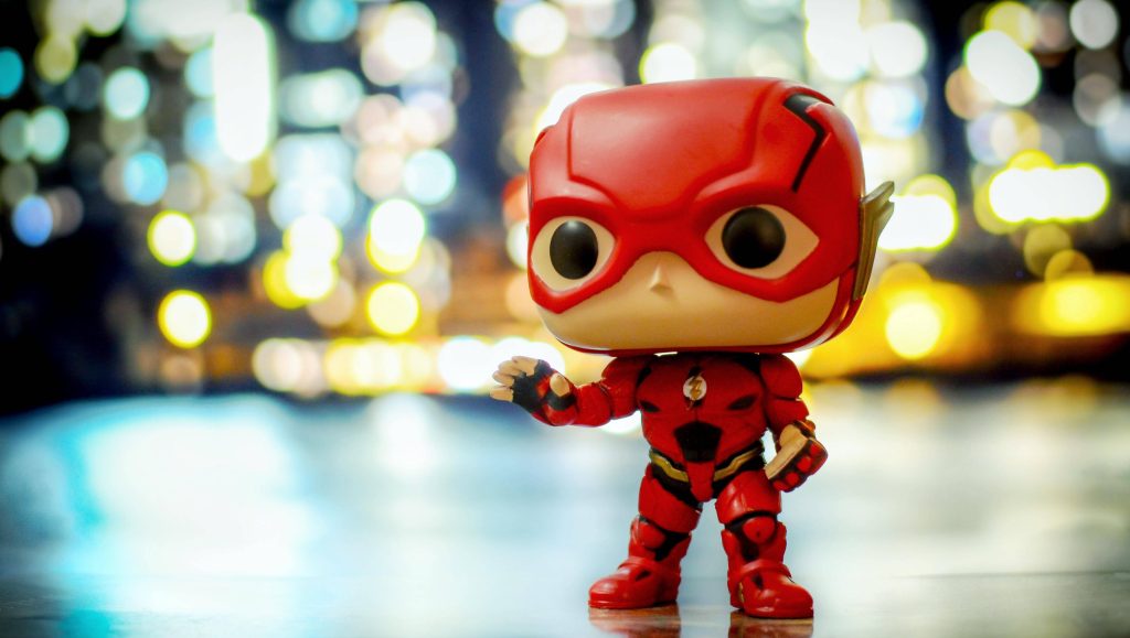 Funko Pop Flash figure in red armored suit with colorful city lights bokeh background wallpaper