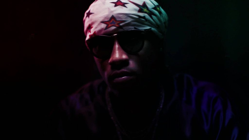 Cinematic portrait of rapper Future in star-patterned durag and shades with moody red teal lighting Wallpaper