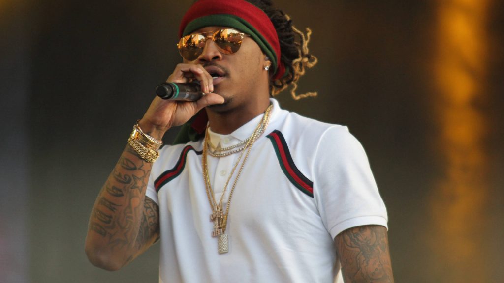 Future rapper performing live on stage wearing white polo and gold chains concert wallpaper