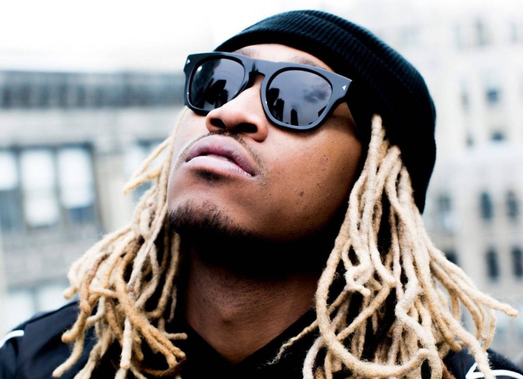 Portrait of rapper Future with blonde dreadlocks black beanie and sunglasses urban background wallpaper