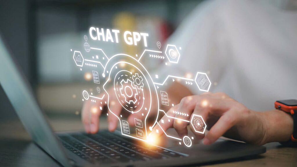 Person typing on laptop with glowing ChatGPT interface digital wallpaper showing AI innovation