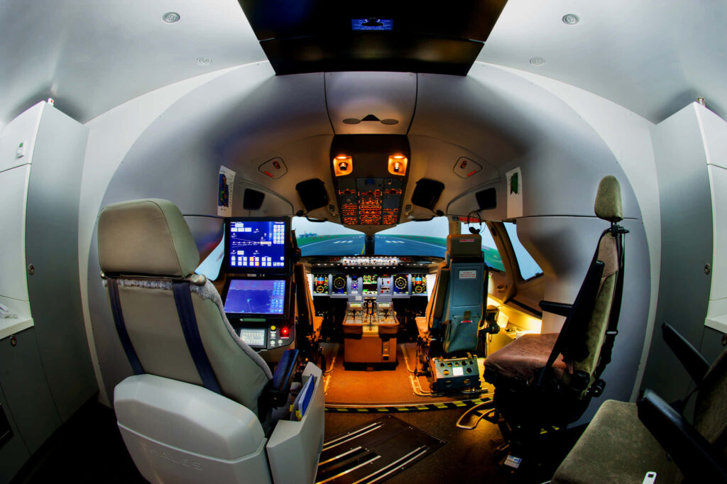 High tech commercial airplane cockpit interior with illuminated controls and panoramic sky views Wallpaper