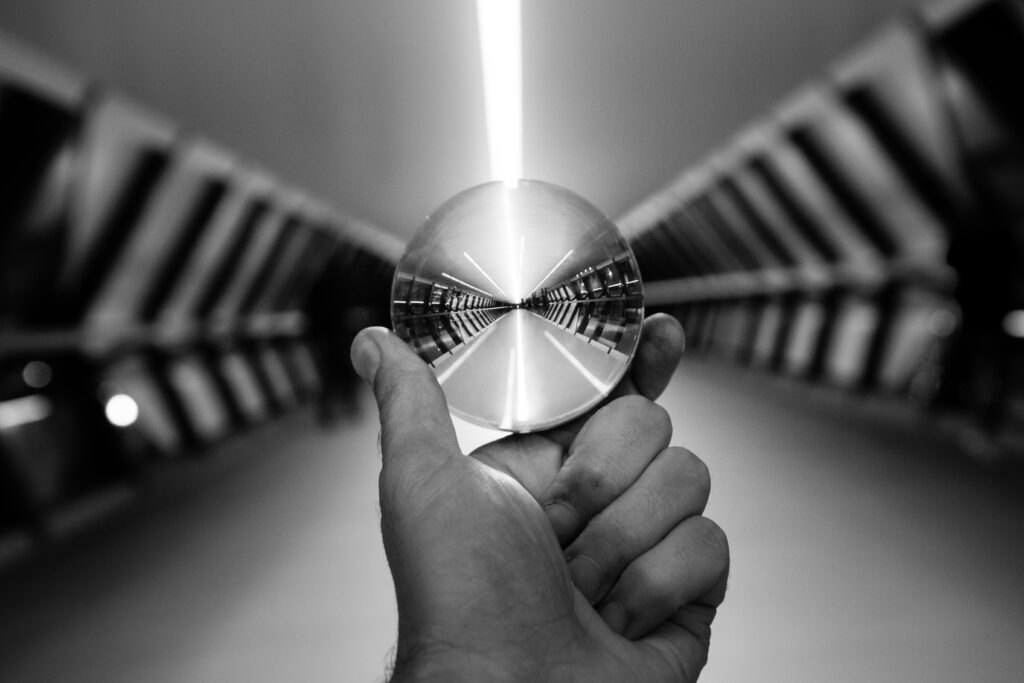 Futuristic Black & White Wallpaper: Hand Holding Glass Ball Reflection