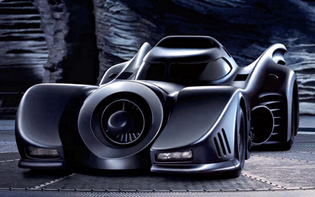 Sleek black Batmobile shining in Batcave futuristic design Batman monster car wallpaper background