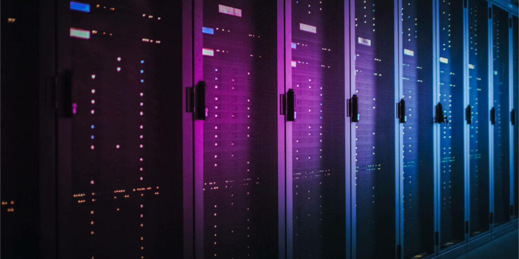 Futuristic data center with colorful purple pink and blue lit server racks showcasing digital innovation Wallpaper