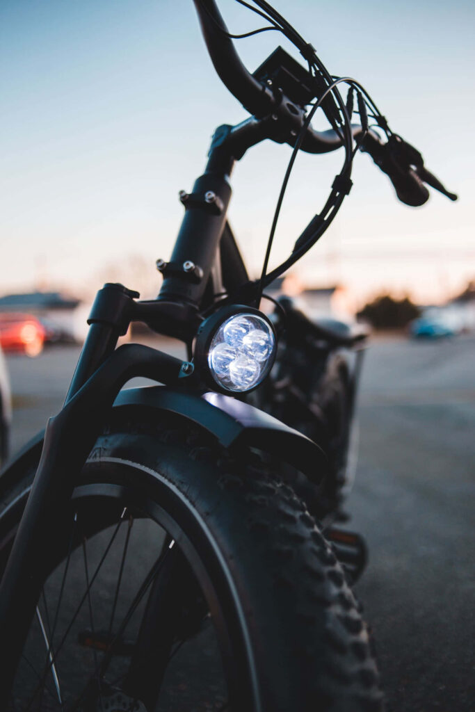 Sleek electric bike with chunky tires and bright headlight on minimalist blurred cool background Wallpaper