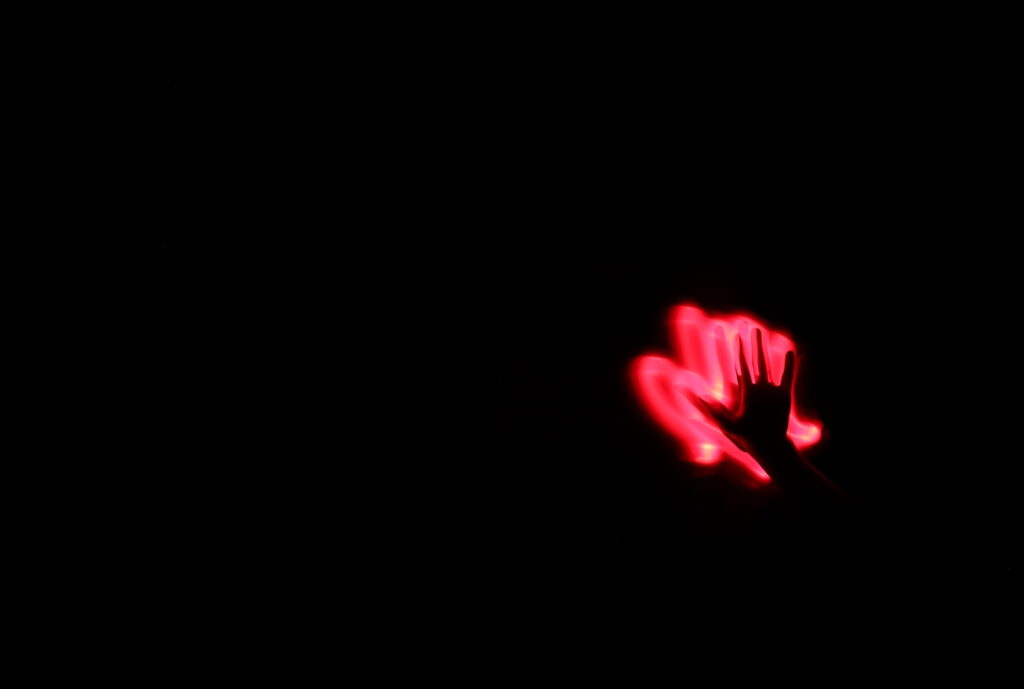 Futuristic Neon Pink Hand Wallpaper on Black Background