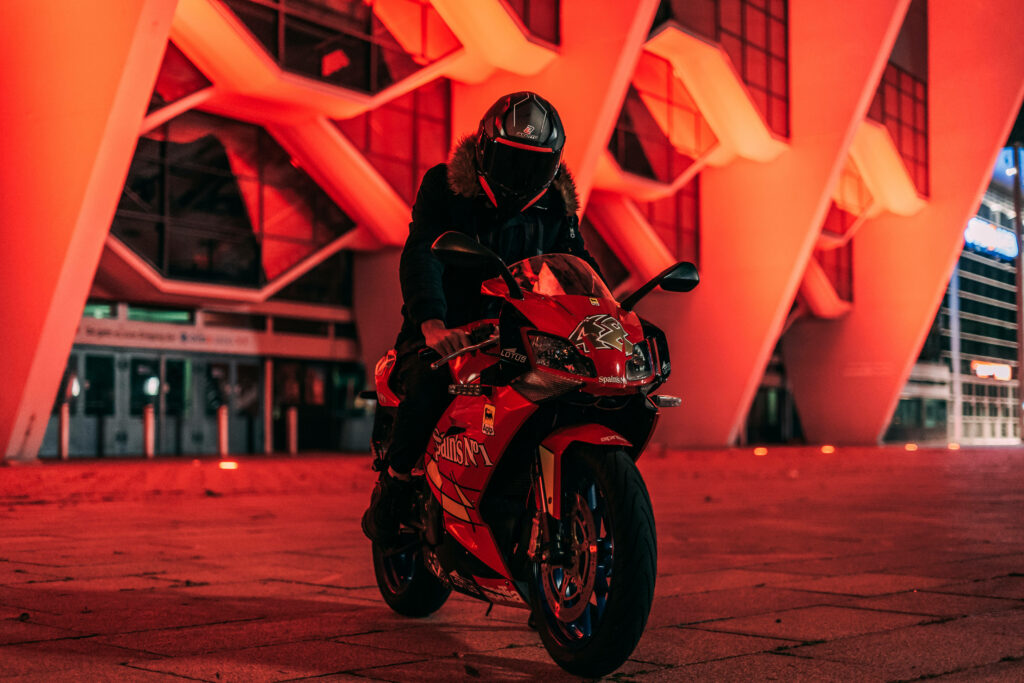 Futuristic Wallpaper: Man on Vibrant Red Bike in Dynamic Setting