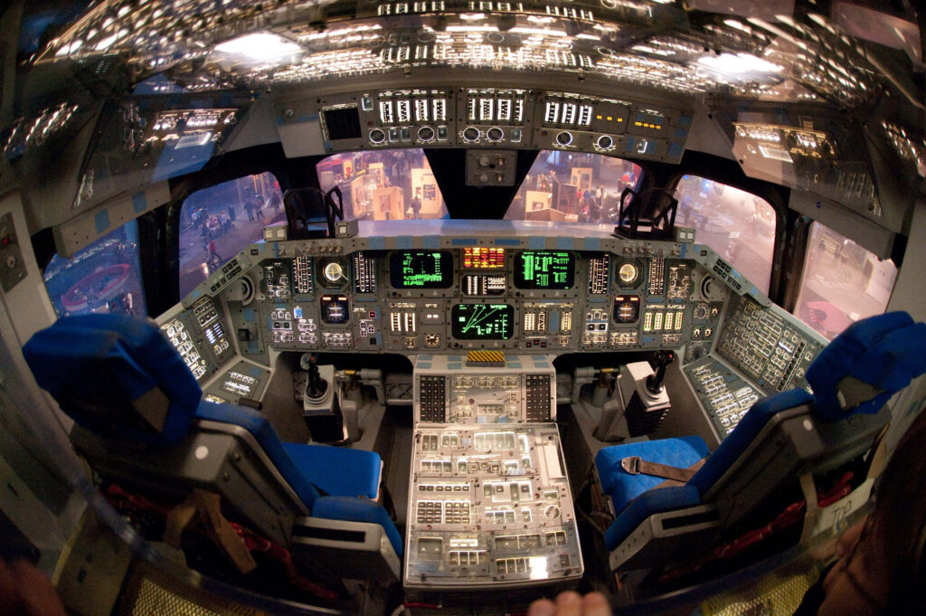 Space shuttle cockpit with illuminated controls blue seats and futuristic space technology interior Wallpaper