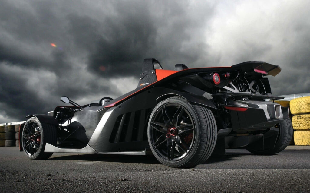 HD wallpaper of sleek futuristic sports car on racetrack under dramatic storm clouds background