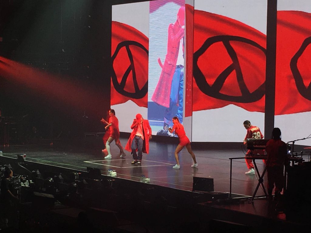 G-Dragon live in red coat and cap performing with dancers and PEACEMINUSONE logo backdrop Wallpaper