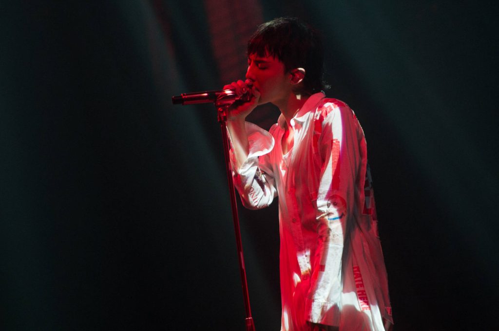 G-Dragon live performance in red stage lighting singing passionately dark moody background wallpaper