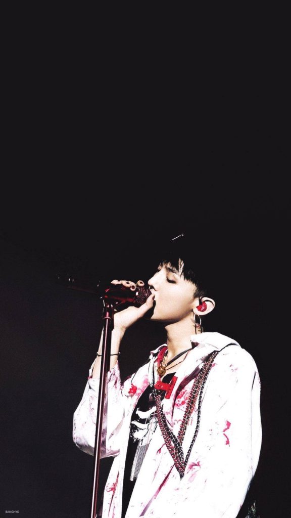 G-Dragon performing live in bold white jacket dark moody background K-pop concert wallpaper