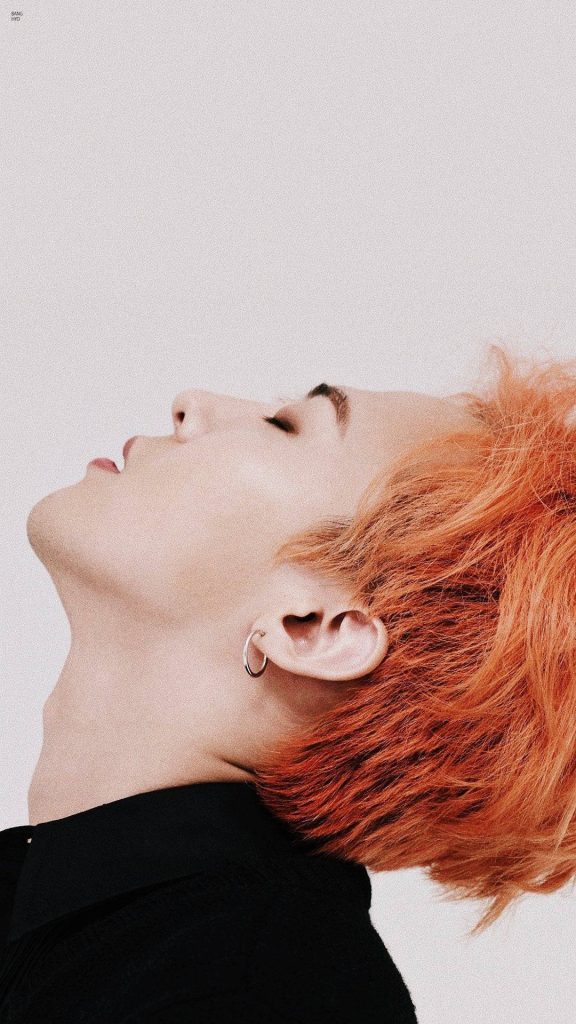 G-Dragon side profile wallpaper with vibrant orange hair silver hoop earring black shirt minimal design