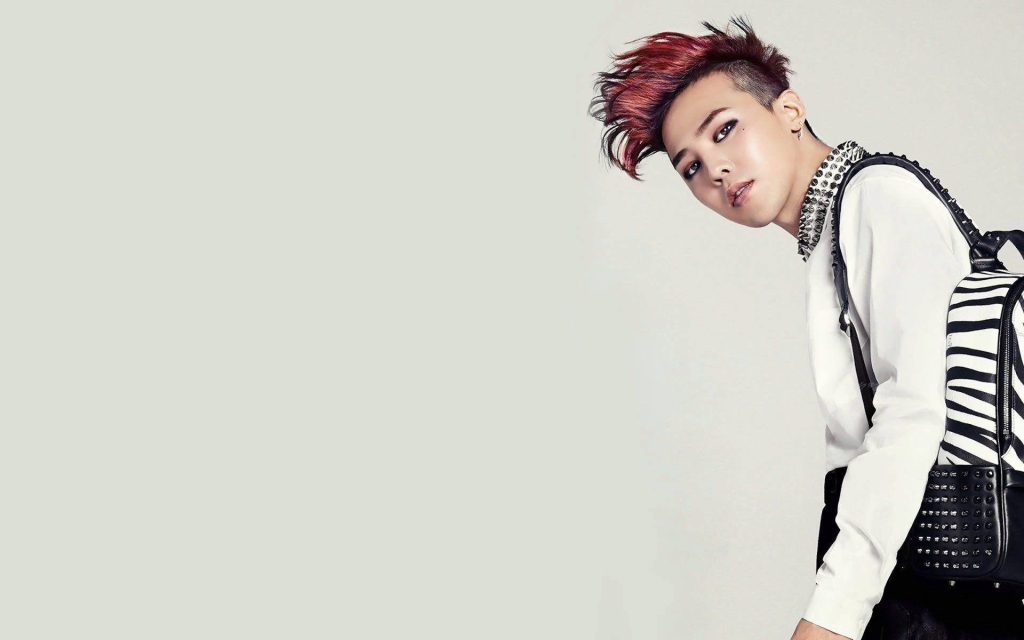 K-pop star G-Dragon with red hawk hairstyle white top studded backpack on grey background wallpaper