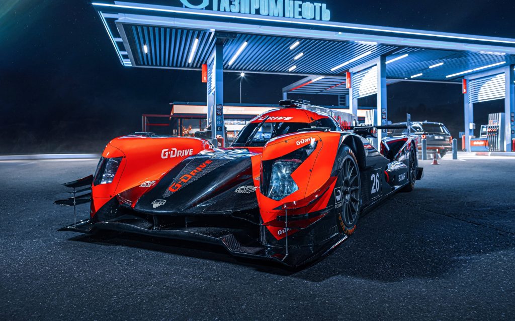 G-Drive Racing Oreca 07 prototype in vibrant orange black at Gazprom Neft station night wallpaper